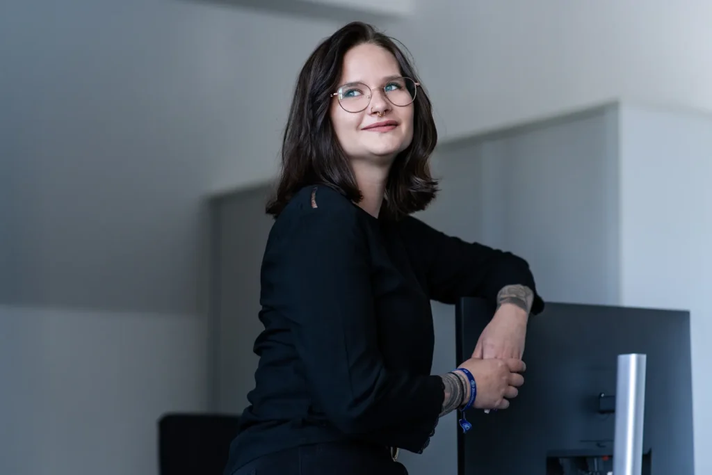 Eine Frau lehnt an einem Bildschirm