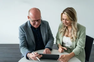 Ein Mann und eine Frau schauen auf ein Tablet